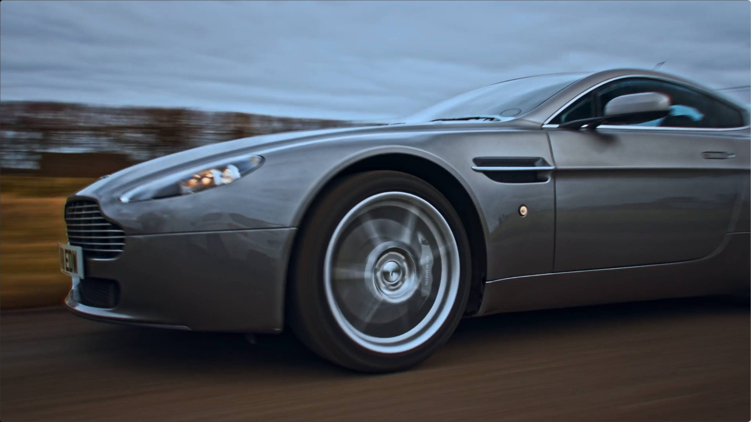 Aston martin front profile – Lumira Studio aston martin on road running from front left angle front wheel – Lumira Studio