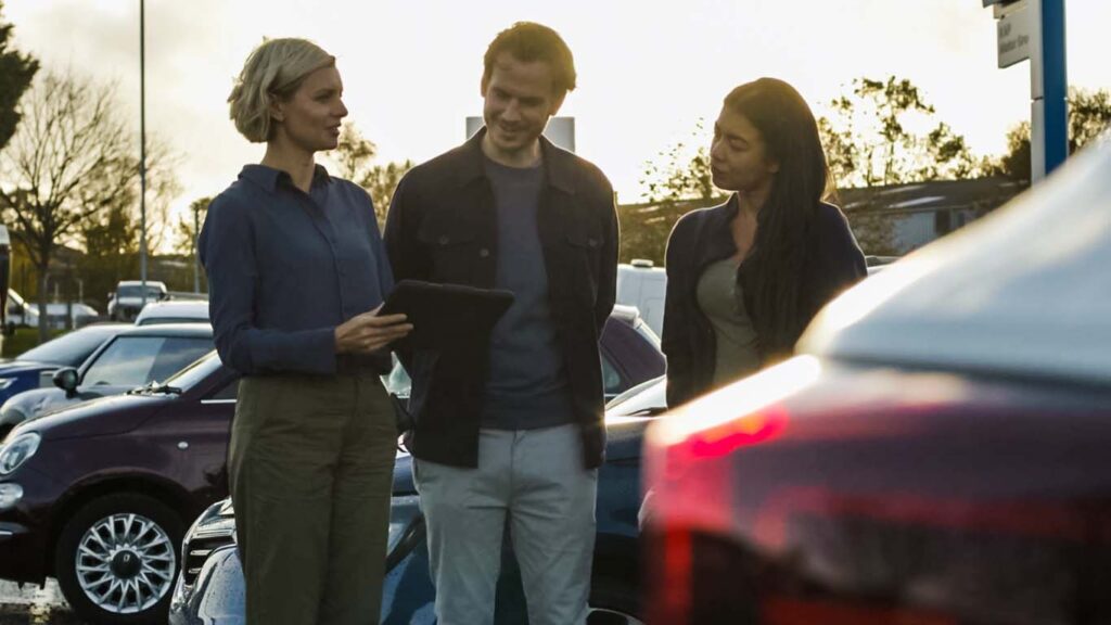 Car dealership selling cars to a couple