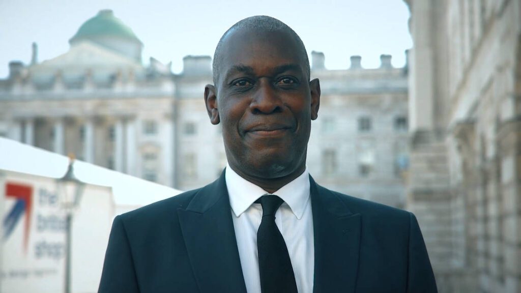 a black male guard look into the camera smiling with confident