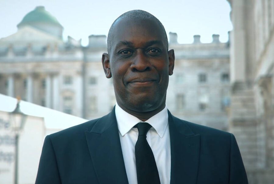 a black male guard look into the camera smiling with confident