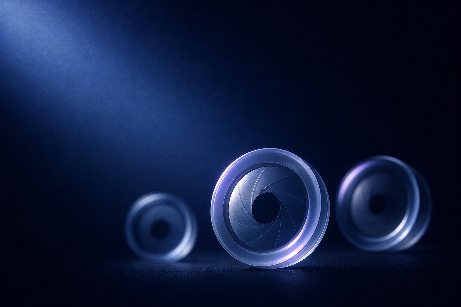 5mobl3-1 – Lumira Studio Three translucent circular lens elements arranged on a dark blue surface, illuminated by cool blue light. – Lumira Studio