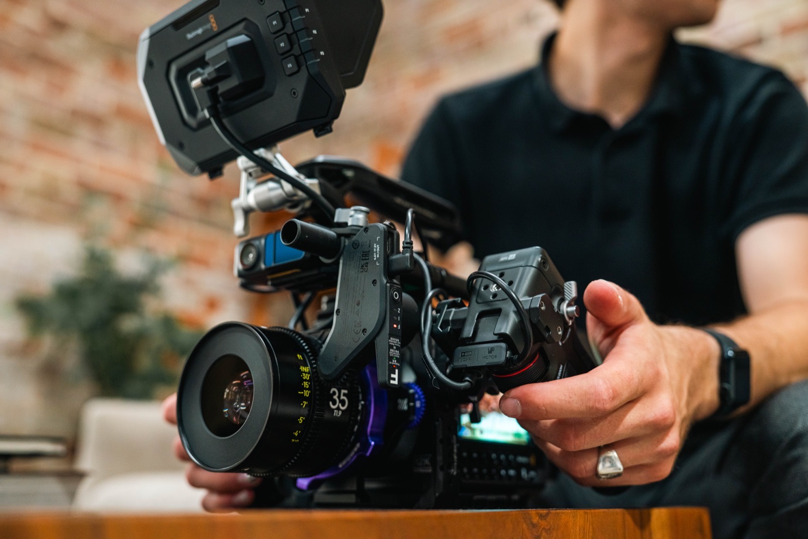 Hands setting up a cinema camera rig with a 35mm prime lens fitted